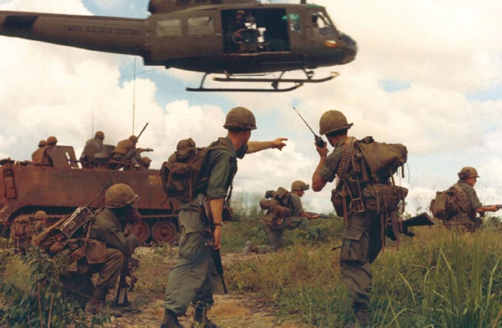 Members of the US Army engaged in combat under a helicopter 
