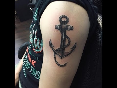 An anchor tattoo on the arm of a young man. 