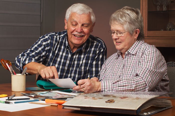 elderly people looking through a photo album