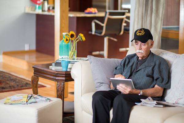 War Veteran using a tablet on his couch
